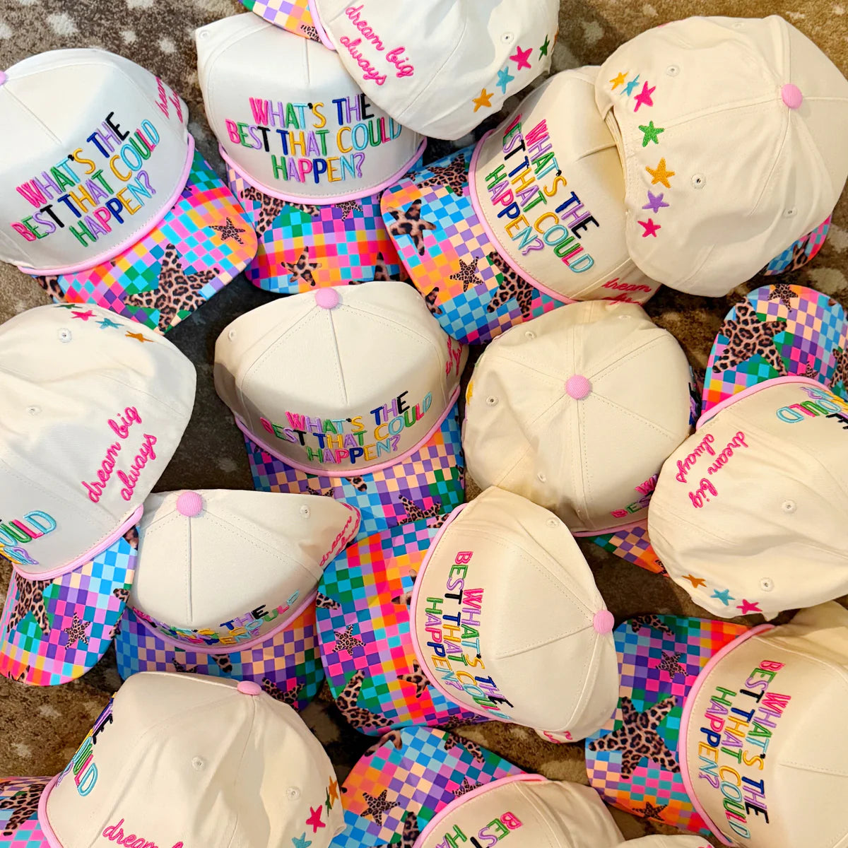 Colorful children's hats with text on a checkered surface