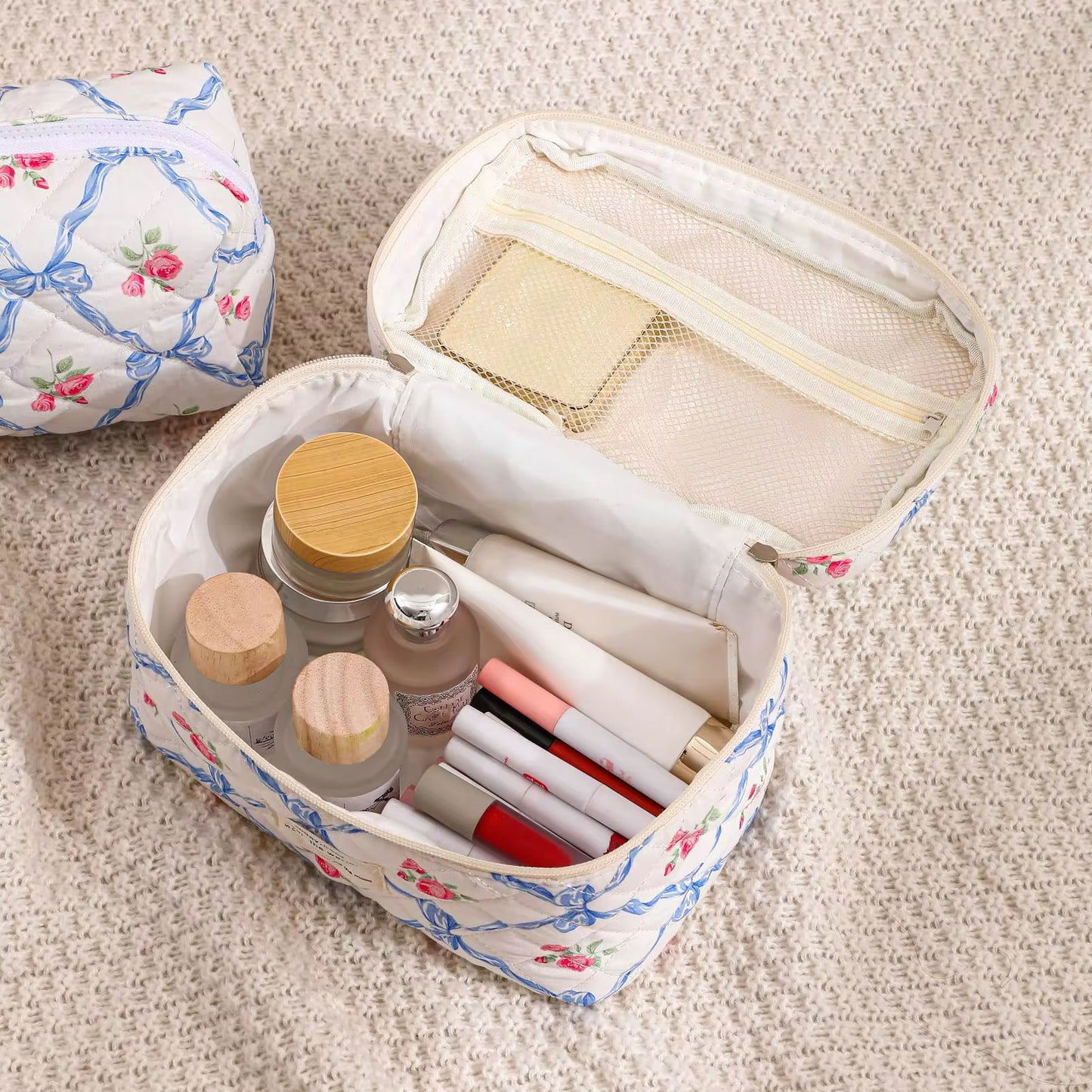Heart-shaped makeup bag with cosmetic items on a textured surface