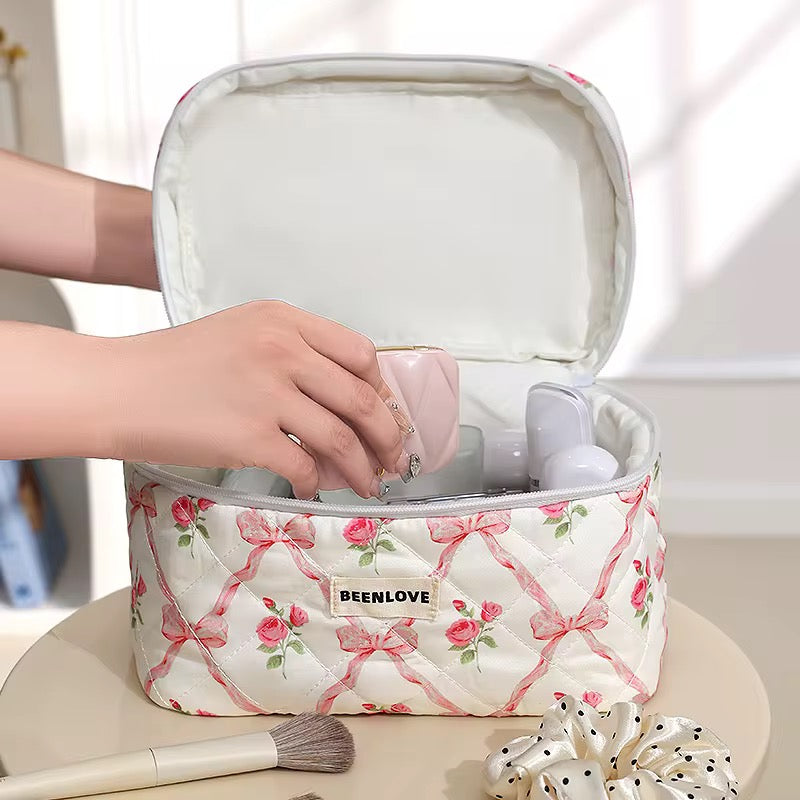 Floral-patterned cosmetic bag with 'BEENLOVE' branding, containing makeup items.