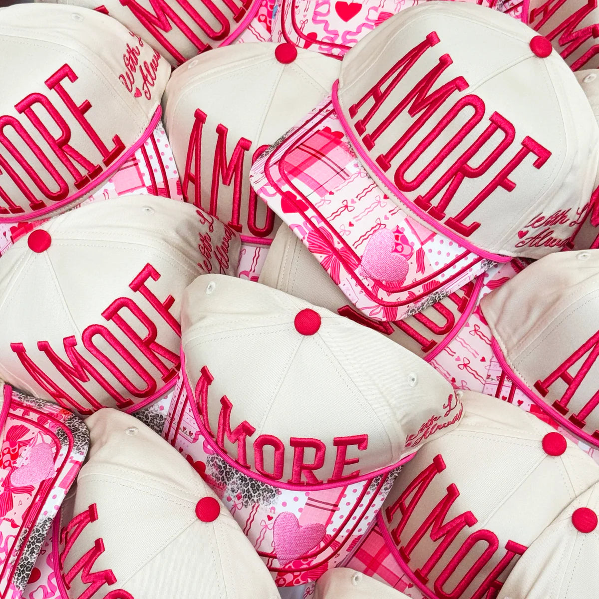 White and pink hats with 'AMORE' text and heart designs.