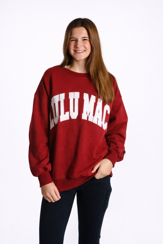 Person wearing a red sweatshirt with 'LULU MAC' text on a white background