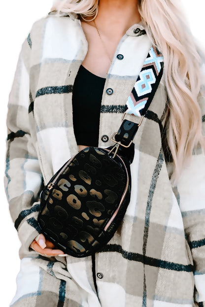 A person wearing a black and white checkered bag with a cheetah print pattern and an Aztec strap.