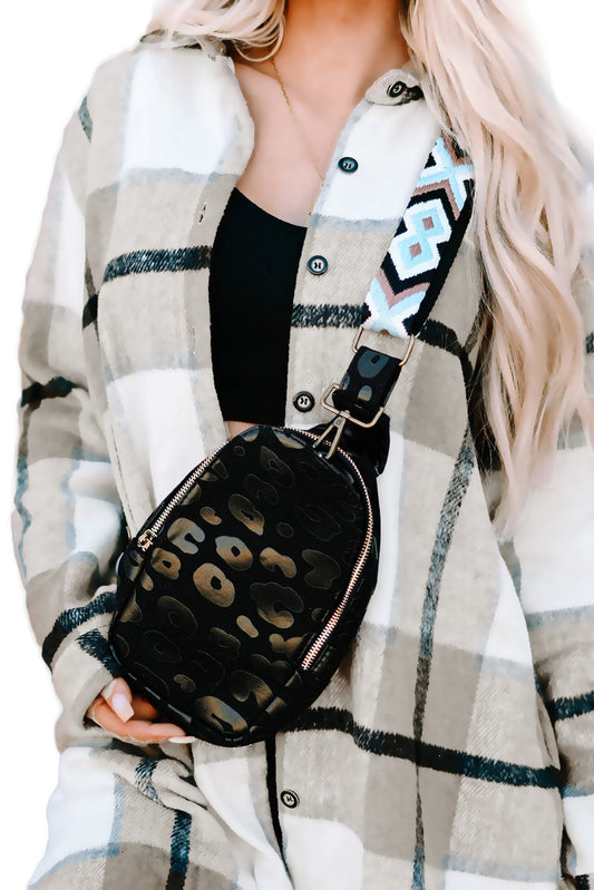 A person wearing a black and white checkered bag with a cheetah print pattern and an Aztec strap.