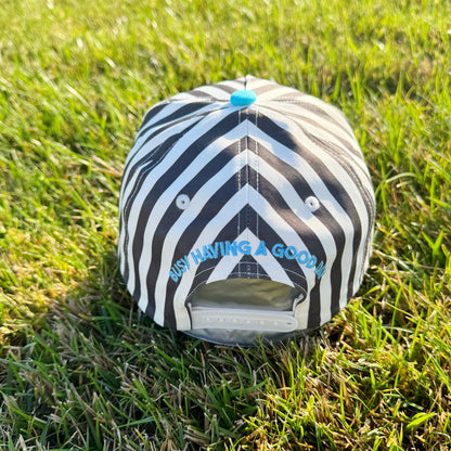 Black and white striped pet bed with blue text on grass