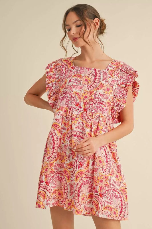 Woman wearing a colorful patterned dress on a beige background