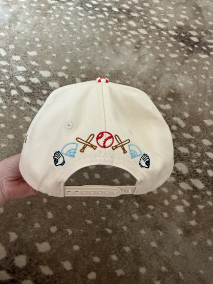 White cap with colorful symbols held against a patterned background