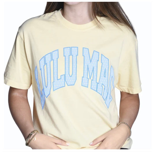 Person wearing a light yellow t-shirt with 'Lulu Mags' printed in blue on a white background