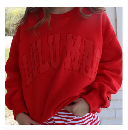 Red sweatshirt with 'Lulumar' text worn by a person, outdoor setting