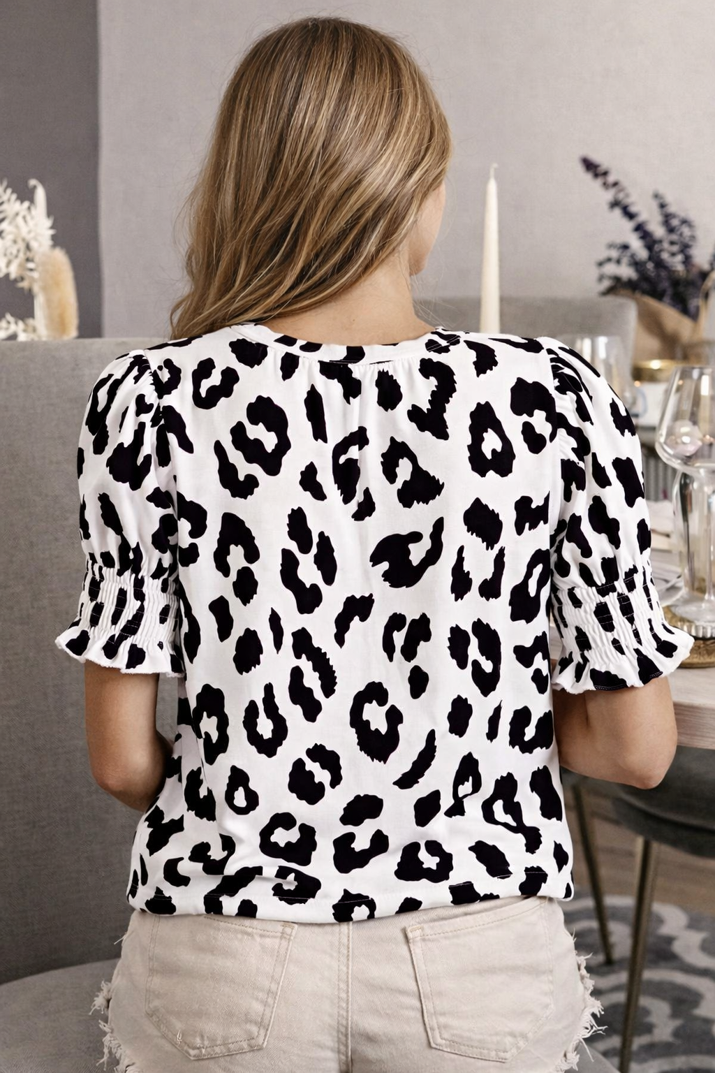 Person wearing a leopard print top in a casual setting