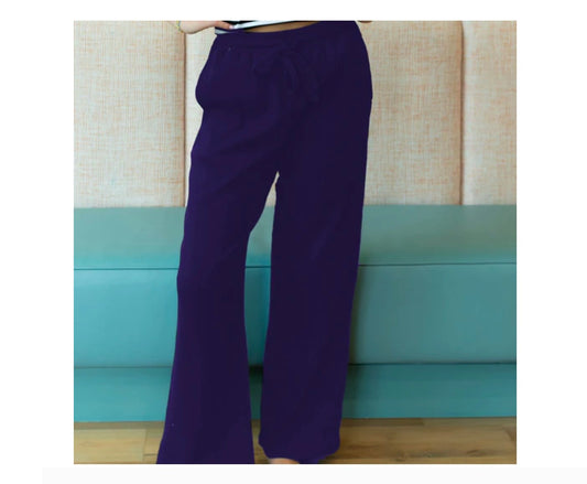 Person wearing purple pants standing against a light blue couch.